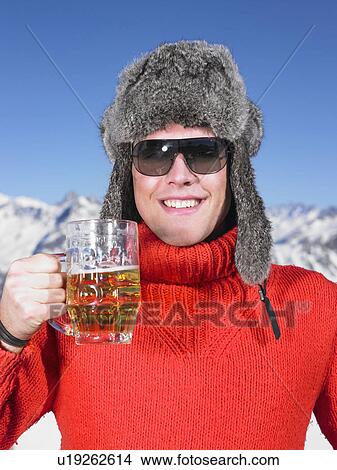 Picture - Young man having drink at mountains. Fotosearch