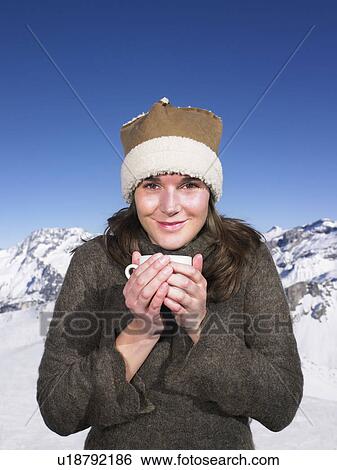 Stock Photograph - Young woman having drink at mountains. Fotosearch