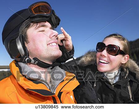 Stock Photography - Young woman putting sunscreen on friend. Fotosearch