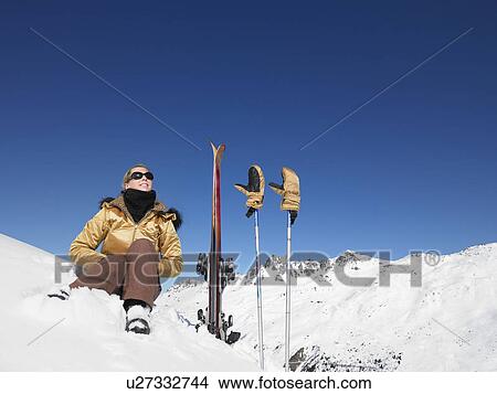 Picture - Young woman skier admiring mountain view. Fotosearch
