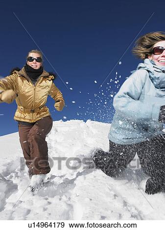 Young women running in snow View Large Photo Image Stock Photo - Young women running in snow. Fotosearch