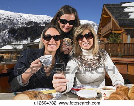 Stock Image - Young women with phone on terrace. Fotosearch