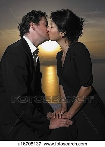 Stock Photo - Couple kissing, sunset. Fotosearch