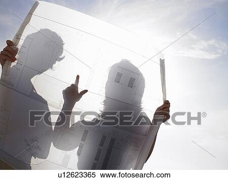 Couple looking at a blueprint View Large Photo Image Stock Photography - Couple looking at a blueprint. Fotosearch