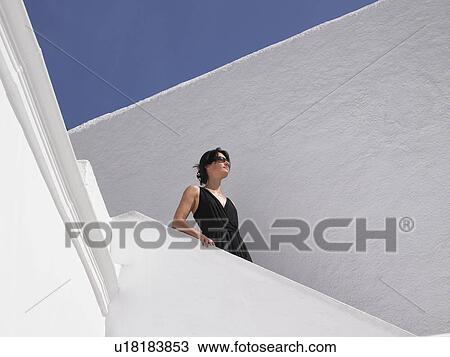 Stock Image - Woman climbing down the stairs. Fotosearch