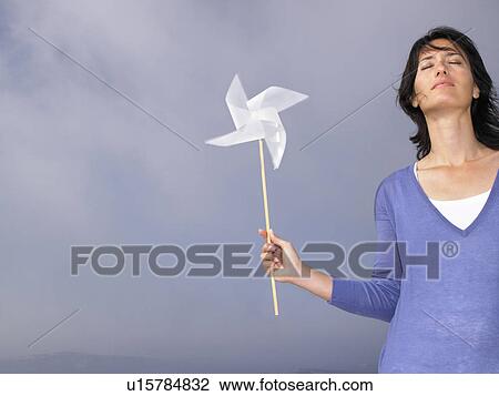 Woman holding a windmill View Large Photo Image Stock Image - Woman holding a windmill. Fotosearch