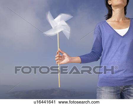 Woman holding a windmill View Large Photo Image Stock Image - Woman holding a windmill. Fotosearch