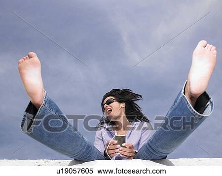 Woman listening to music with ear phones View Large Photo Image Stock Photography - Woman listening to music with ear phones. Fotosearch
