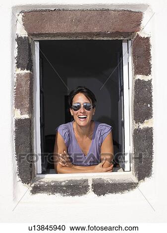 Woman looking through window, smiling View Large Photo Image Stock Image - Woman looking through window, smiling. Fotosearch