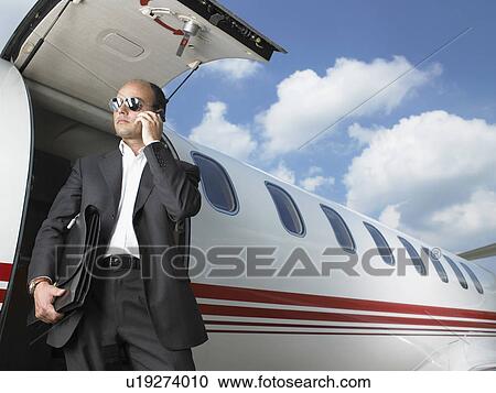 Businessman exiting jet while on phone. View Large Photo Image Stock Image - Businessman exiting jet while on phone.. Fotosearch