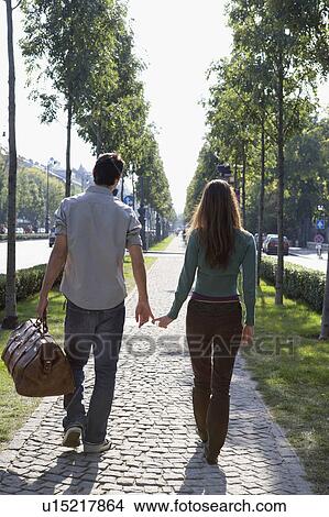 Couple walking together with a large bag. View Large Photo Image Picture - Couple walking together with a large bag.. Fotosearch