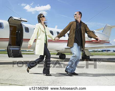 Happy couple running out of private jet. View Large Photo Image Stock Photo - Happy couple running out of private jet.. Fotosearch