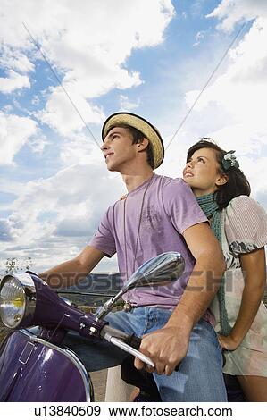 Stock Photo - Man and woman on scooter.. Fotosearch