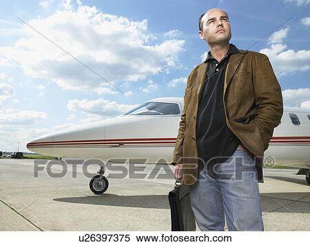 Man standing next to private jet. View Large Photo Image Stock Photography - Man standing next to private jet.. Fotosearch