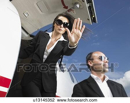 Offensive businesswoman and businessman exiting private jet. View Large Photo Image Stock Image - Offensive businesswoman and businessman exiting private jet.. Fotosearch