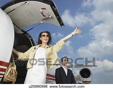 Smiling woman exiting private jet with bodyguard. View Large Photo Image Stock Photo - Smiling woman exiting private jet with bodyguard.. Fotosearch
