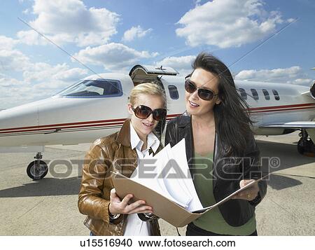 Two businesswomen working in front of private jet. View Large Photo Image Stock Image - Two businesswomen working in front of private jet.. Fotosearch