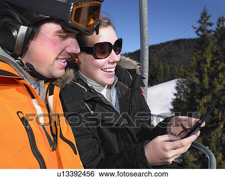 Couple playing game on ski-lift View Large Photo Image Stock Photograph - Couple playing game on ski-lift. Fotosearch