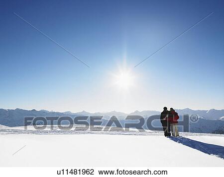 Couple walking in snow on mountain top View Large Photo Image Stock Image - Couple walking in snow on mountain top. Fotosearch