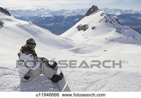 Stock Photograph - Female snowboarder resting. Fotosearch
