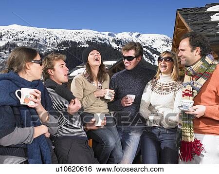 Stock Photograph - Group of friends on terrace at mountains. Fotosearch