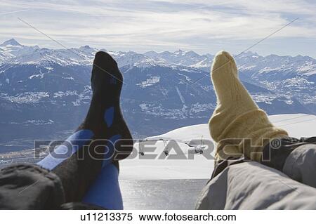 Stock Photography - Resting feet on bench with mountain view. Fotosearch