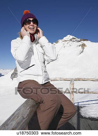 Stock Image - Woman listening to music on terrace. Fotosearch