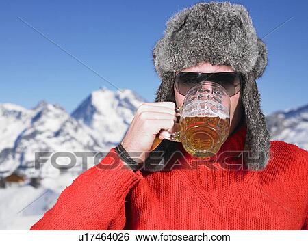 Stock Photograph - Young man having drink at mountains. Fotosearch