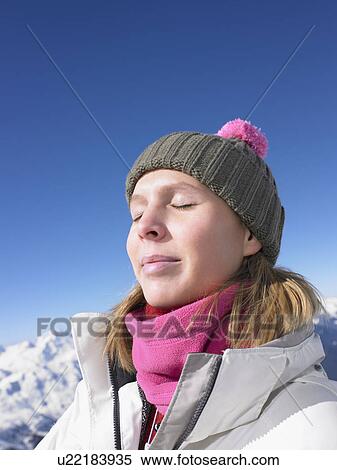 Stock Photography - Young woman enjoying sun at mountains. Fotosearch