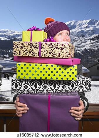 Young woman holding pile of presents View Large Photo Image Stock Image - Young woman holding pile of presents. Fotosearch