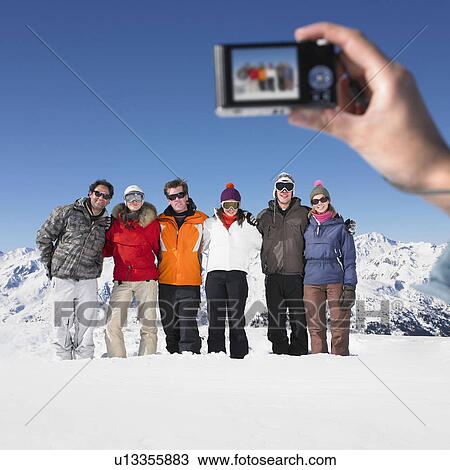 Stock Image - Young woman taking picture of group. Fotosearch