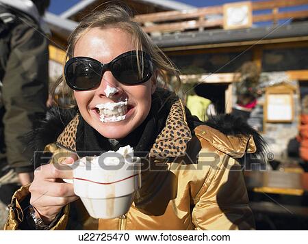 Stock Image - Young woman with whipped cream on lips . Fotosearch