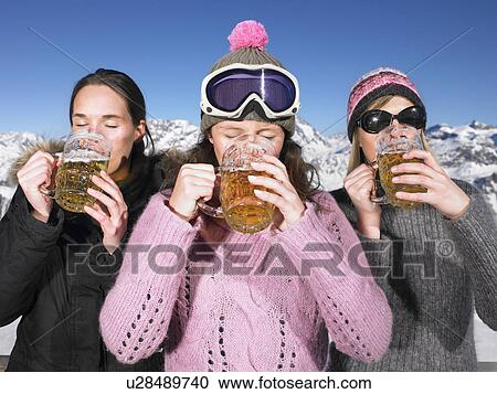 Stock Image - Young women having drink at mountains. Fotosearch