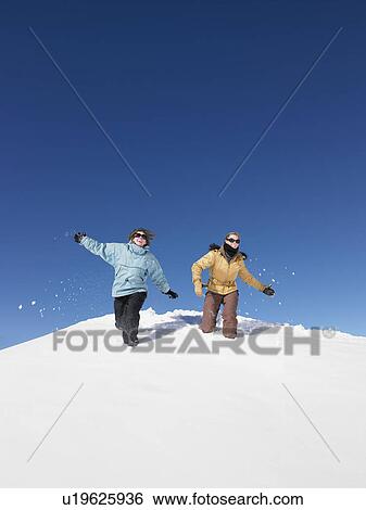 Young women running in snow View Large Photo Image Stock Photograph - Young women running in snow. Fotosearch