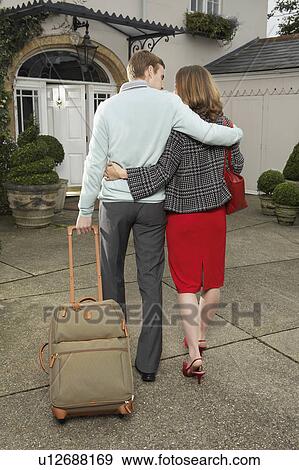 Stock Photo - Man and woman walking with their luggage.. Fotosearch