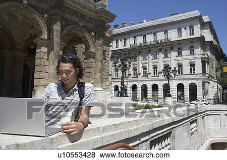 Man on laptop by the opera house in Hungary. View Large Photo Image Stock Photo - Man on laptop by the opera house in Hungary.. Fotosearch