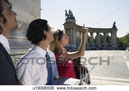 Stock Photograph - Three businesspeople looking at laptop.. Fotosearch