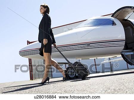 Picture - A business woman leaving a plane. Fotosearch