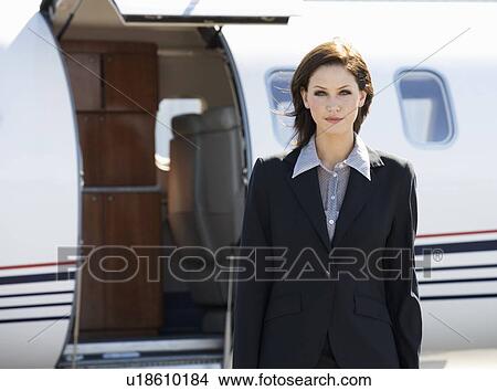 Picture - A business woman standing by a plane. Fotosearch