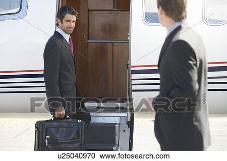 A businessman boarding a plane View Large Photo Image Stock Image - A businessman boarding a plane. Fotosearch
