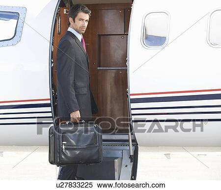Stock Photography - A businessman boarding a plane. Fotosearch
