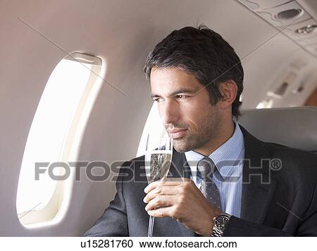 A businessman drinking champagne on a flight View Large Photo Image Stock Image - A businessman drinking champagne on a flight. Fotosearch