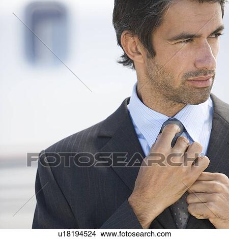 Picture - A businessman standing by a plane. Fotosearch