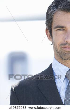 Stock Image - A businessman standing by a plane. Fotosearch