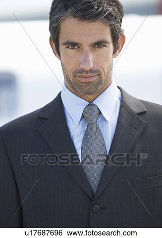 Stock Photograph - A businessman standing by a plane. Fotosearch
