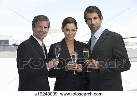 Stock Photo - Three business colleagues drinking champagne. Fotosearch