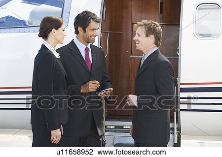 Three business colleagues standing by a plane View Large Photo Image Stock Image - Three business colleagues standing by a plane. Fotosearch
