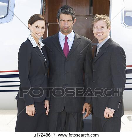 Three business colleagues standing by a plane View Large Photo Image Stock Photo - Three business colleagues standing by a plane. Fotosearch