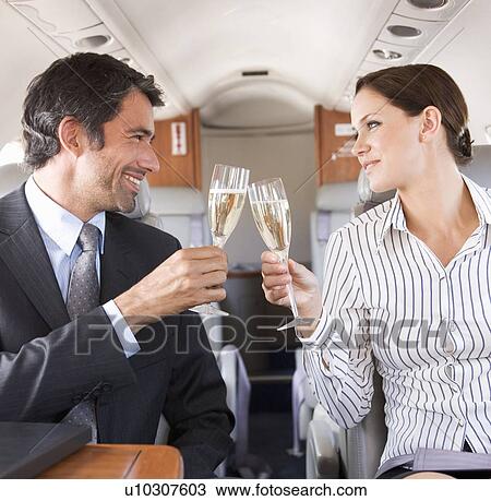 Two business colleagues drinking champagne on a flight View Large Photo Image Stock Image - Two business colleagues drinking champagne on a flight. Fotosearch