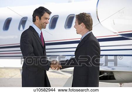 Two business colleagues shaking hands before departure View Large Photo Image Picture - Two business colleagues shaking hands before departure. Fotosearch
